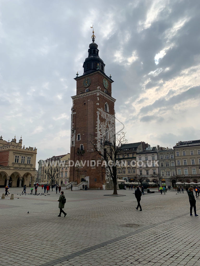 A historic town hall tower overlooking a European market square